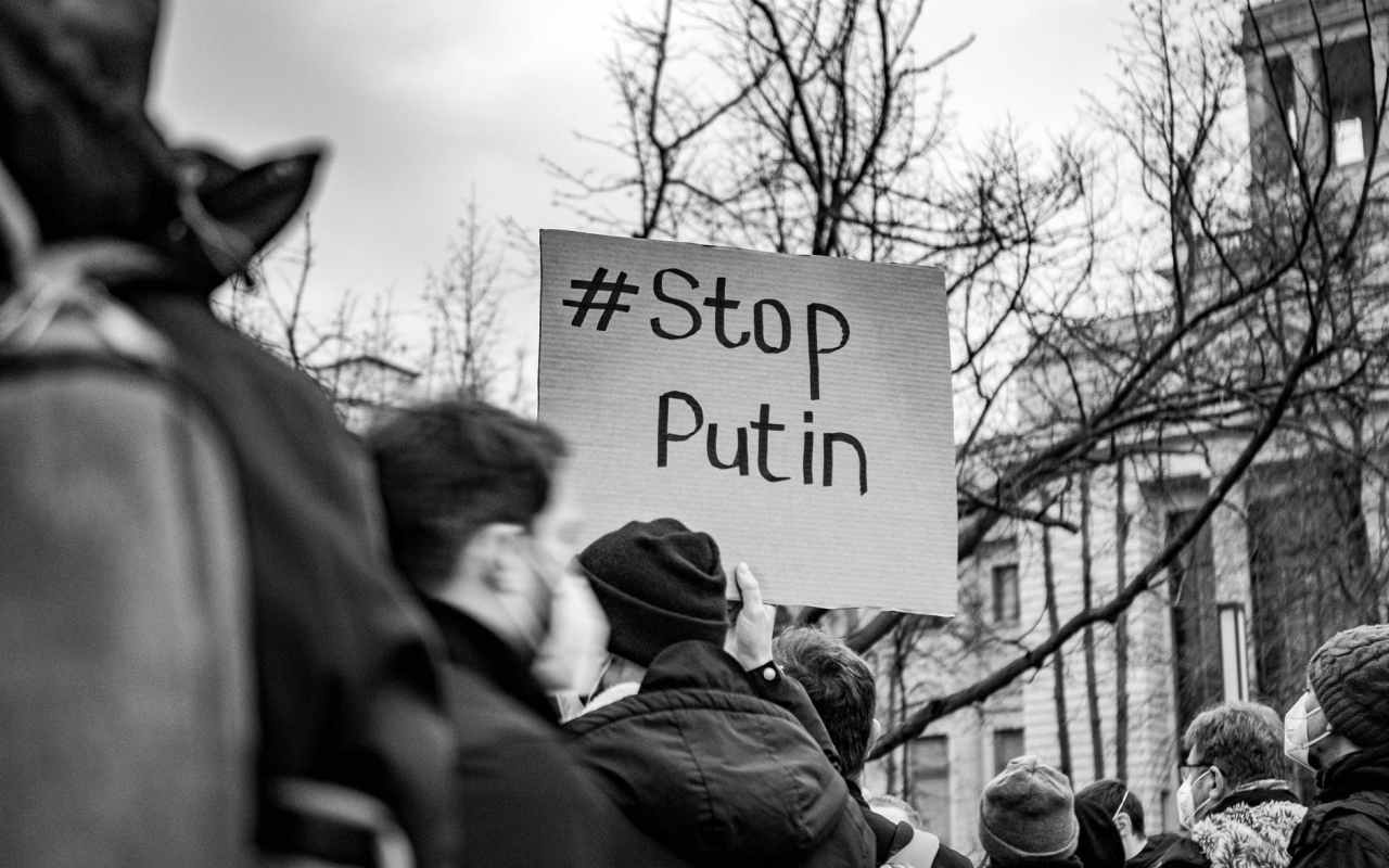 protester holding sign with stop putin on it